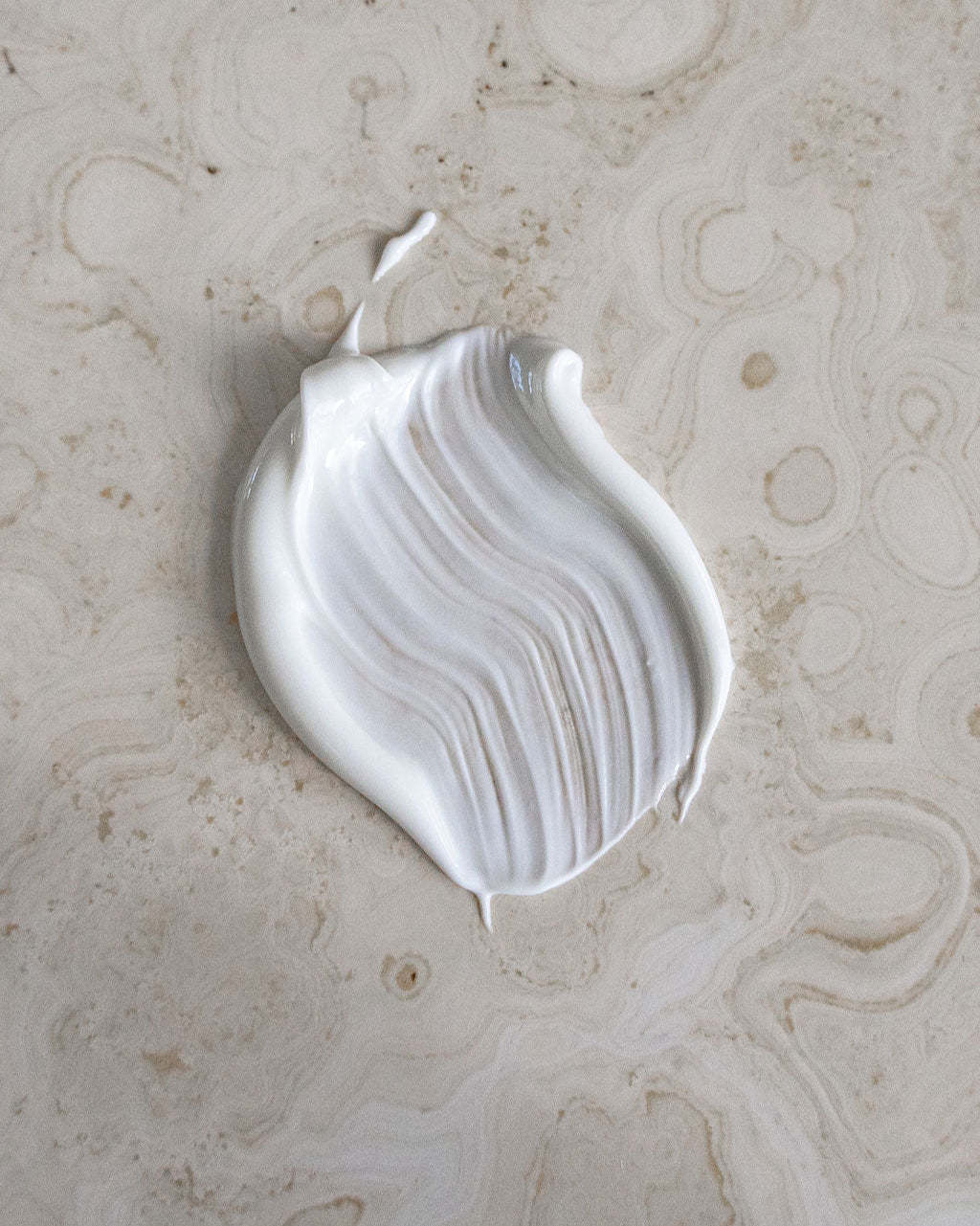 Textur der Healyni Narbencreme auf Stein – cremiger Swatch mit seidigem Finish, Symbol für sanfte Narbenpflege und die regenerierende Scar Care Formula