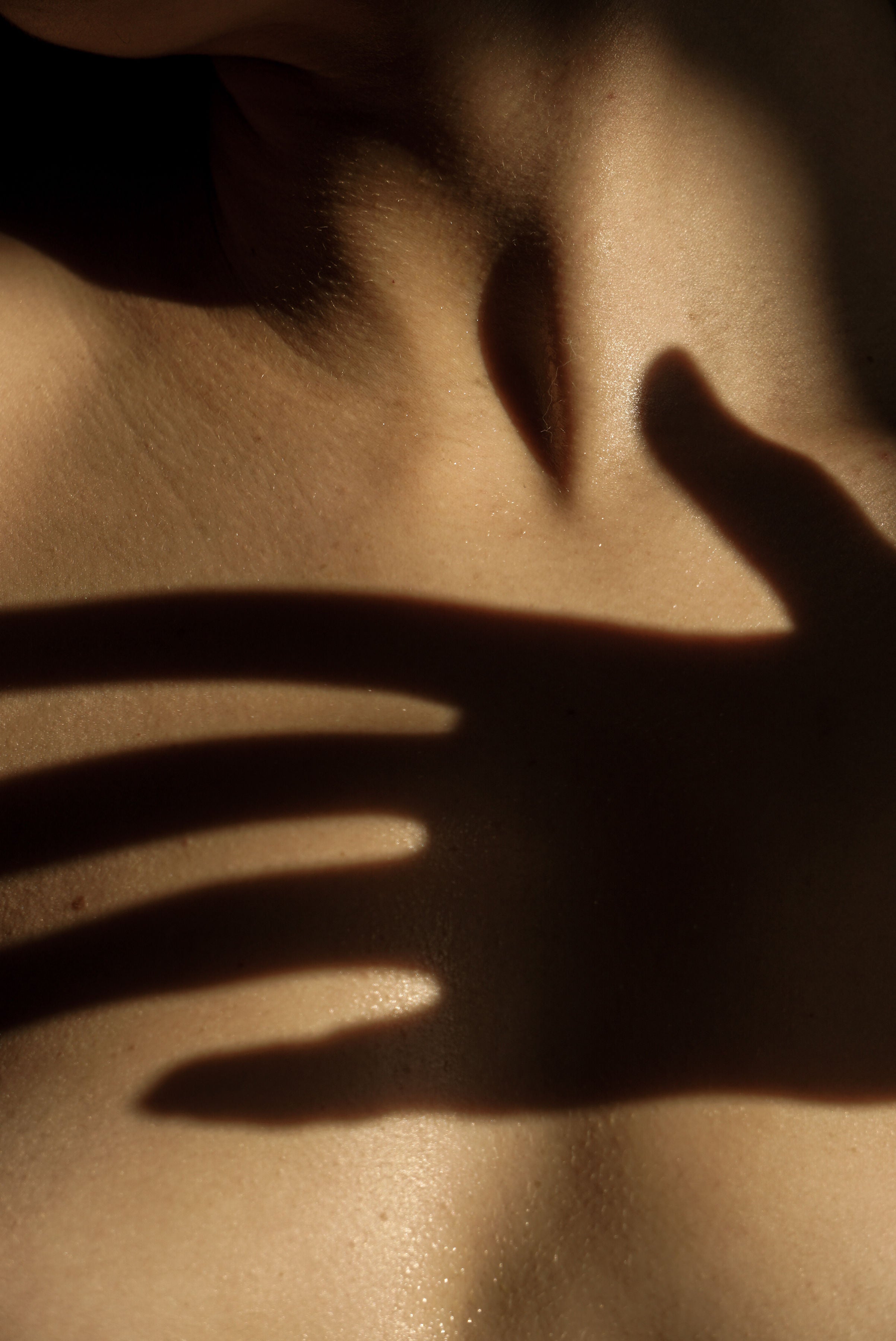 Frau hält sanft ihre Hand auf Haut, sinnliche Szene